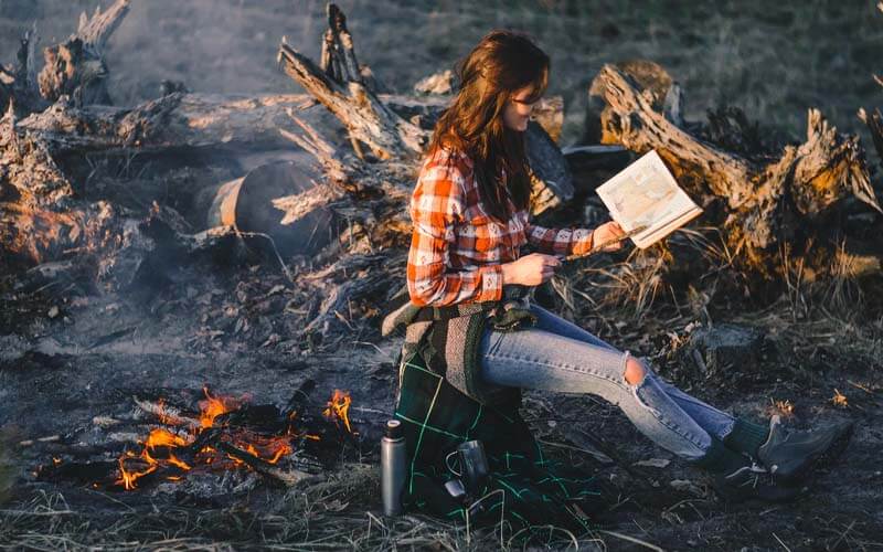 Reading next to campfire